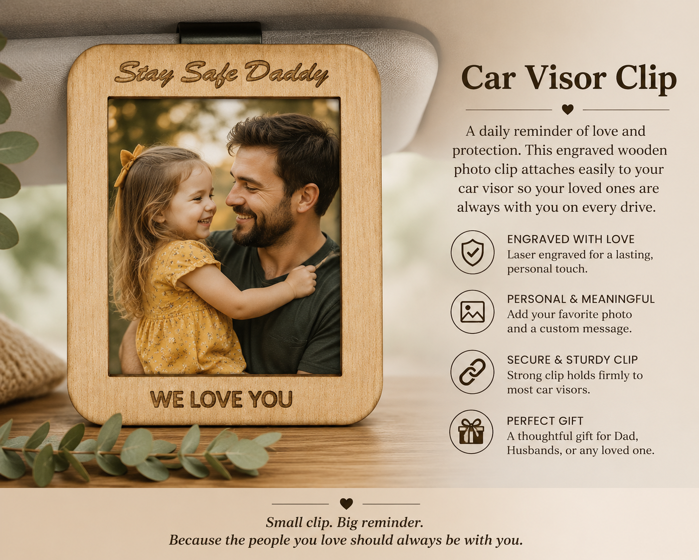 Wooden car visor clip with engraved photo of a man and child, surrounded by greenery.